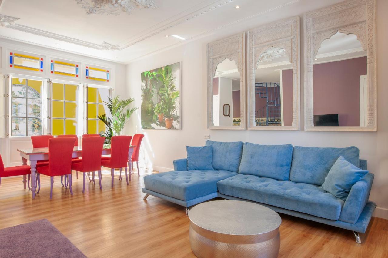 een woonkamer met een blauwe bank en een tafel bij Casa Verde Ayamonte in Ayamonte
