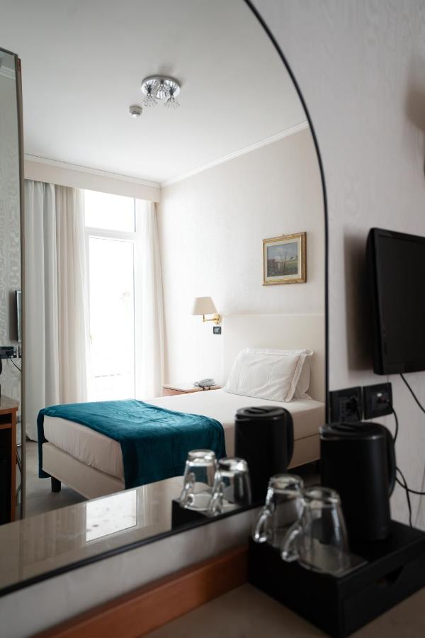 een hotelkamer met een bed en een spiegel bij Hotel Excelsior Bay in Malcesine