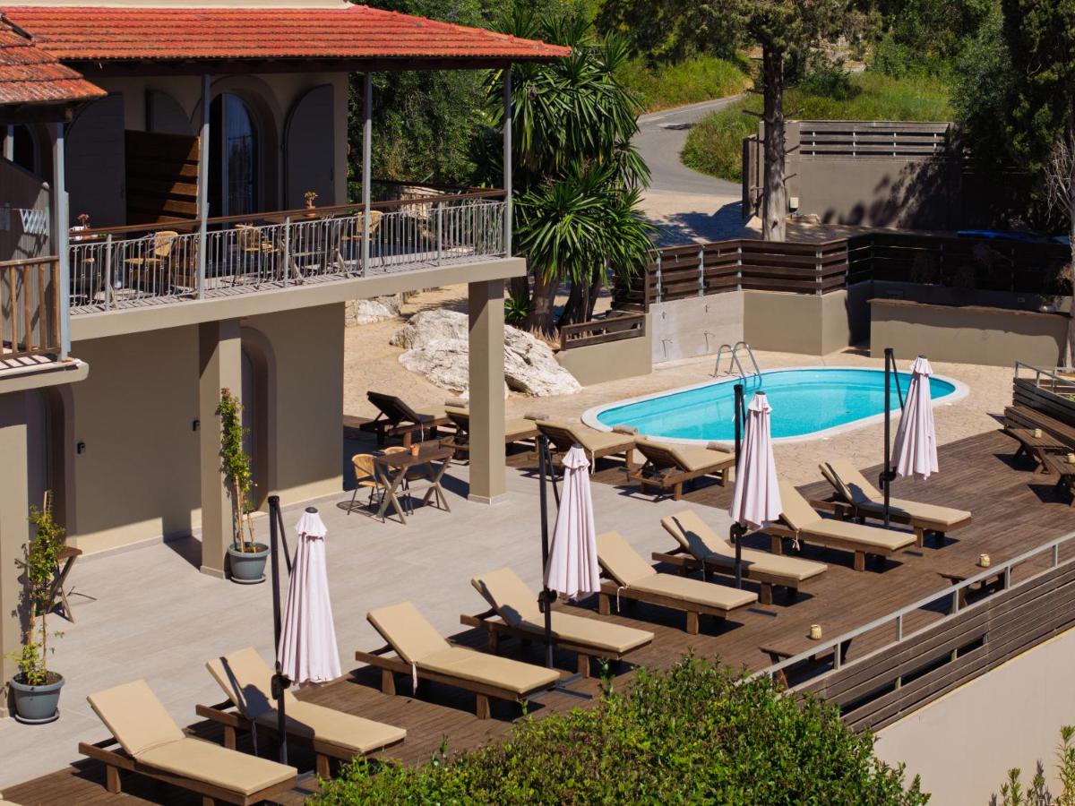 Een foto van het zwembad van een resort met ligstoelen en parasols. bij The Summit Escape in Achílleion