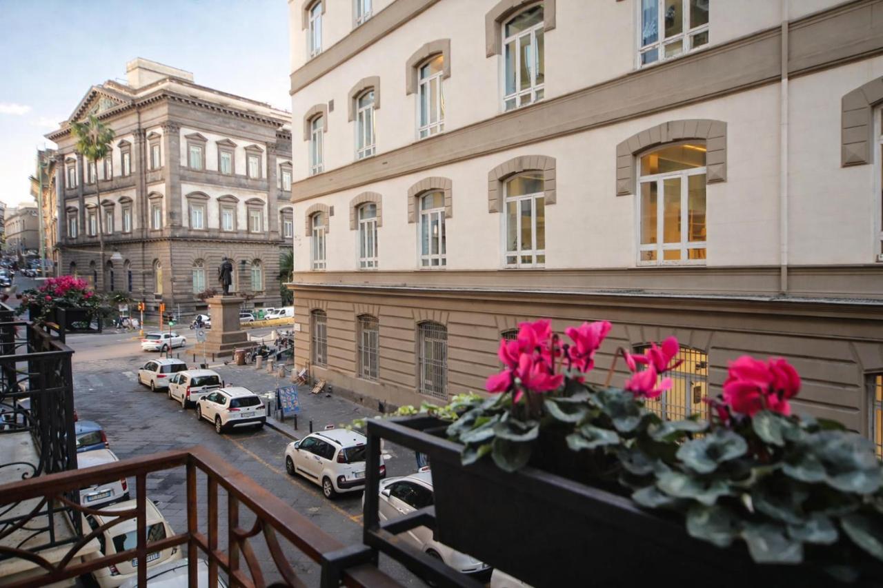 een balkon met roze bloemen aan een stadsstraat bij Mamalu - Corso Umberto 35 - Studios and Suites in Napels