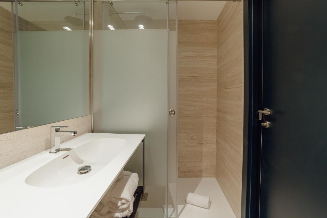 een badkamer met een witte wastafel en een douche bij ABC Hotel Porto - Campanhã in Porto