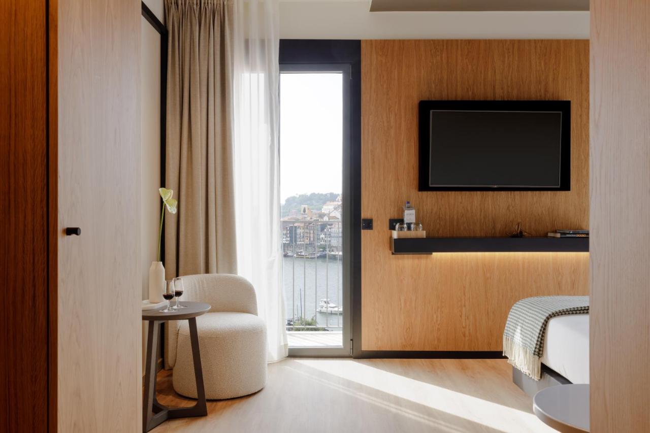 een hotelkamer met een bed en een televisie bij Porto River Soul Hotel in Vila Nova de Gaia