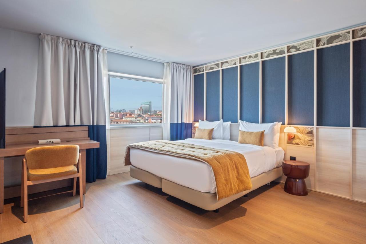 een slaapkamer met een bed, een bureau en een raam bij Hotel Acta Moa in Lissabon