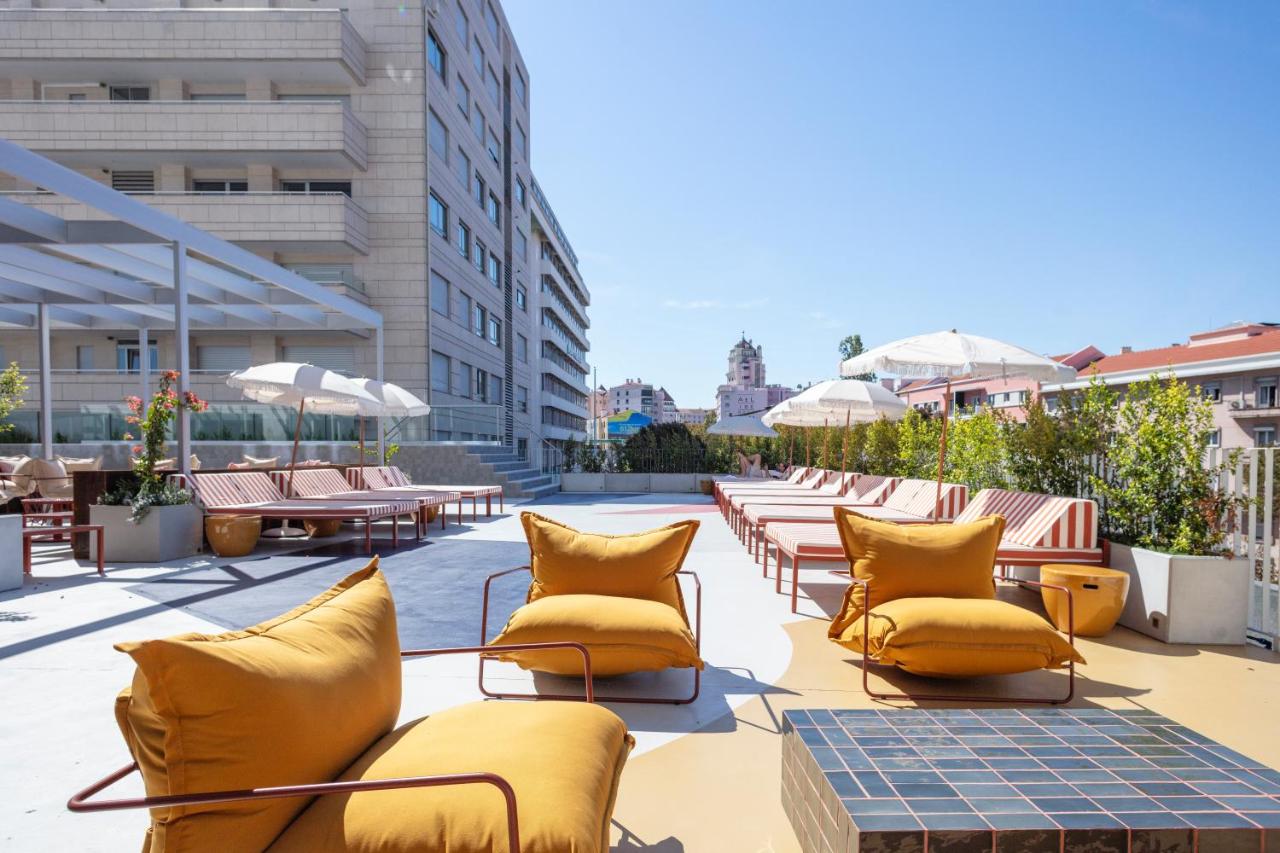 een patio met gele stoelen en tafels en gebouwen bij Hotel Acta Moa in Lissabon