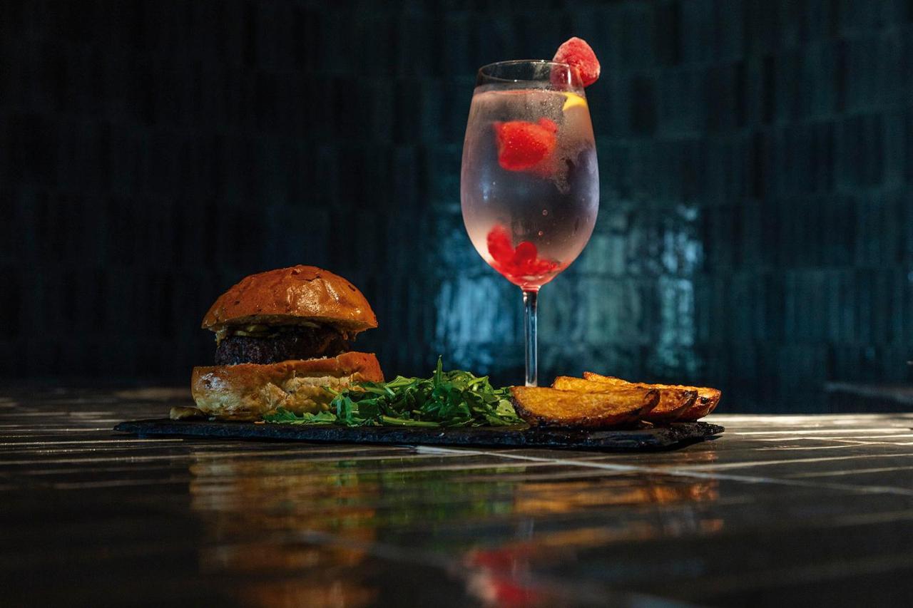Een sandwich en een drankje op een tafel met een bord eten. bij Hotel Acta Moa in Lissabon