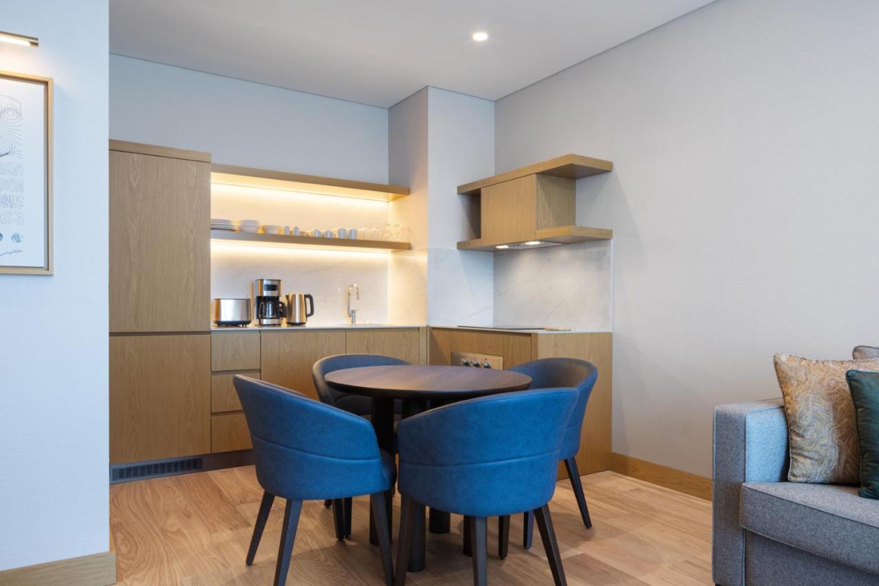 een eetkamer met een tafel en blauwe stoelen bij Marriott Executive Apartments Istanbul Investvadi in Istanbul