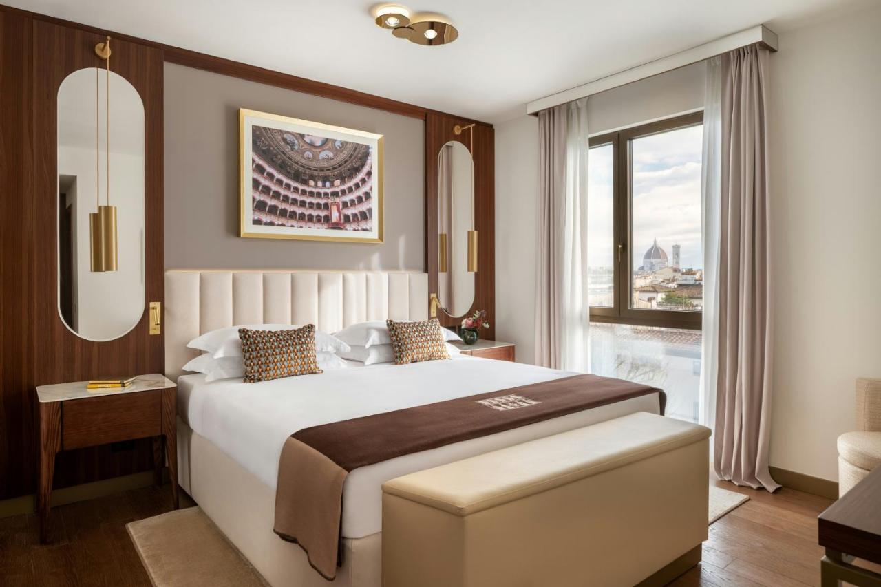 een slaapkamer met een groot wit bed en een raam bij Teatro Luxury Apartments Firenze - Starhotels Collezione in Florenc