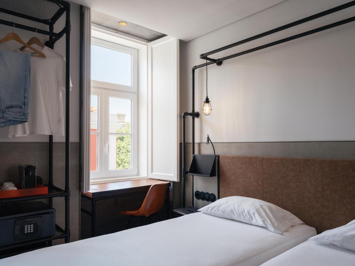 een slaapkamer met een bed en een raam bij Inspira Santos Boutique Hotel in Lissabon
