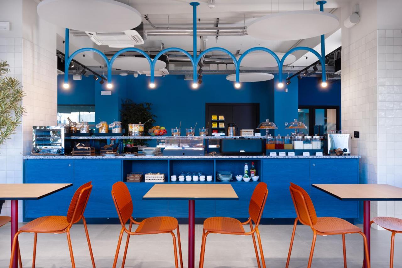 een restaurant met blauwe toonbanken en oranje stoelen bij CX Naples Centrale in Napels