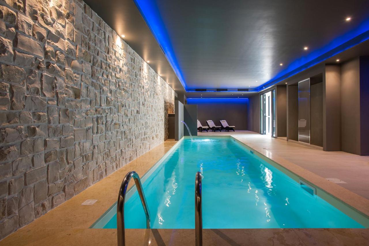 een zwembad in een kamer met een stenen muur bij Fortyfive Squared Hotel in Rome