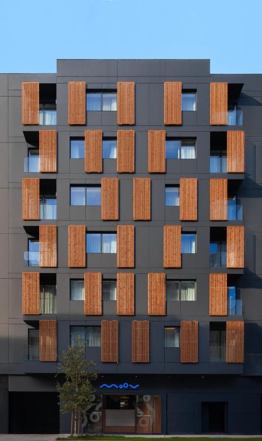 een hoog appartementengebouw met bruine ramen bij Moov Apartments Boavista in Porto