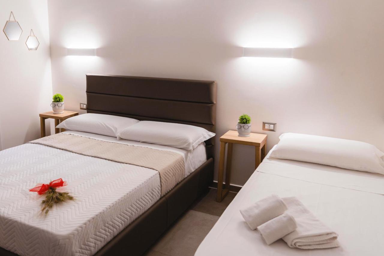 een slaapkamer met twee bedden met een rode strik erop. bij Art Boutique Rooms in Le Castella