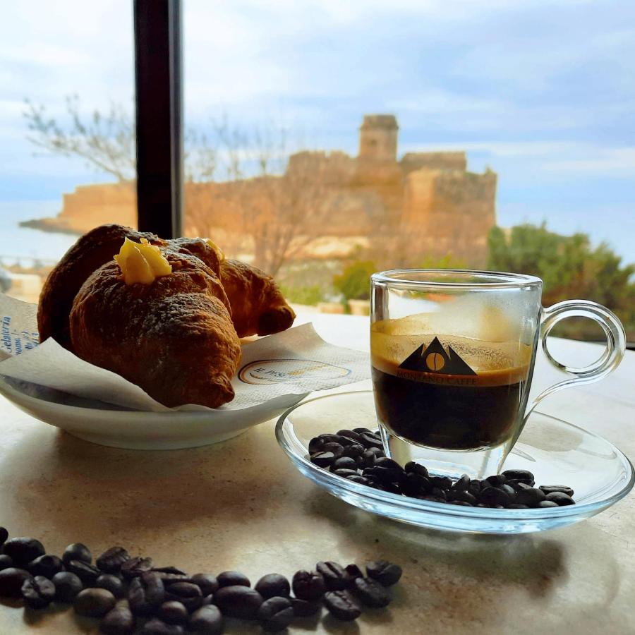 een kop koffie, een croissant en koffiebonen bij Art Boutique Rooms in Le Castella