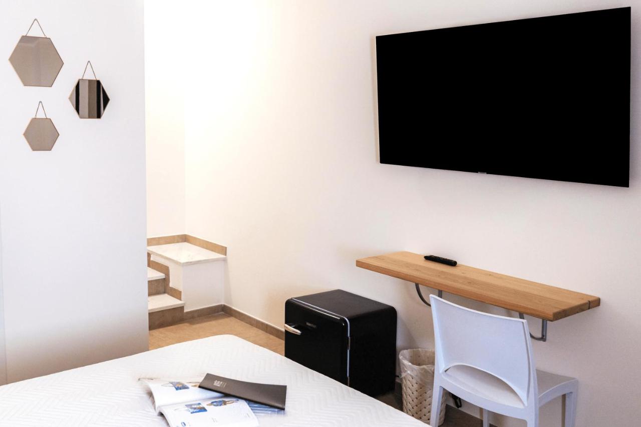 een kamer met een tafel en een tv aan de muur bij Art Boutique Rooms in Le Castella