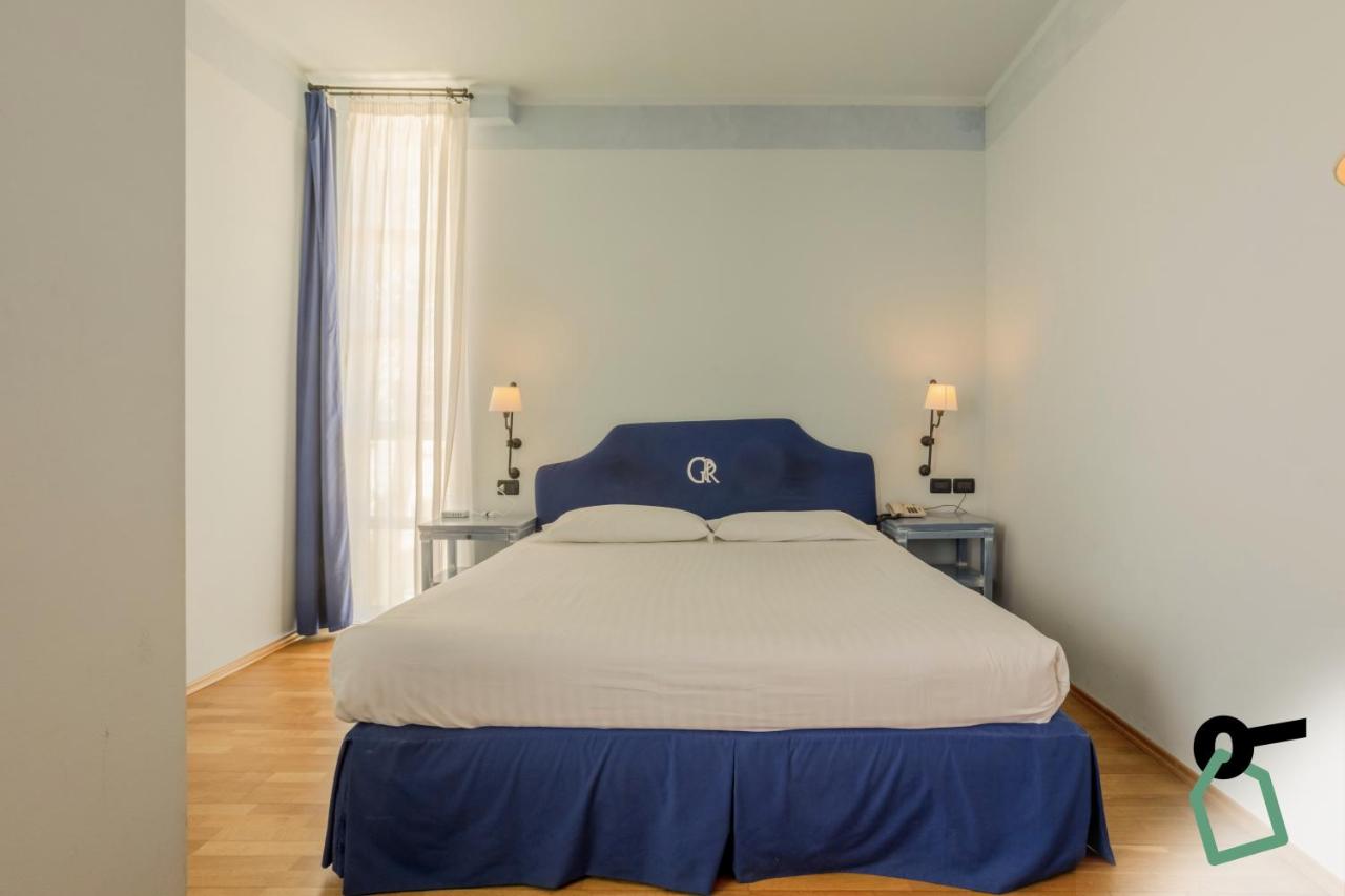 een slaapkamer met een groot bed met een blauw hoofdeinde bij HOTIDAY Room Collection - Calambrone in Tirrenia