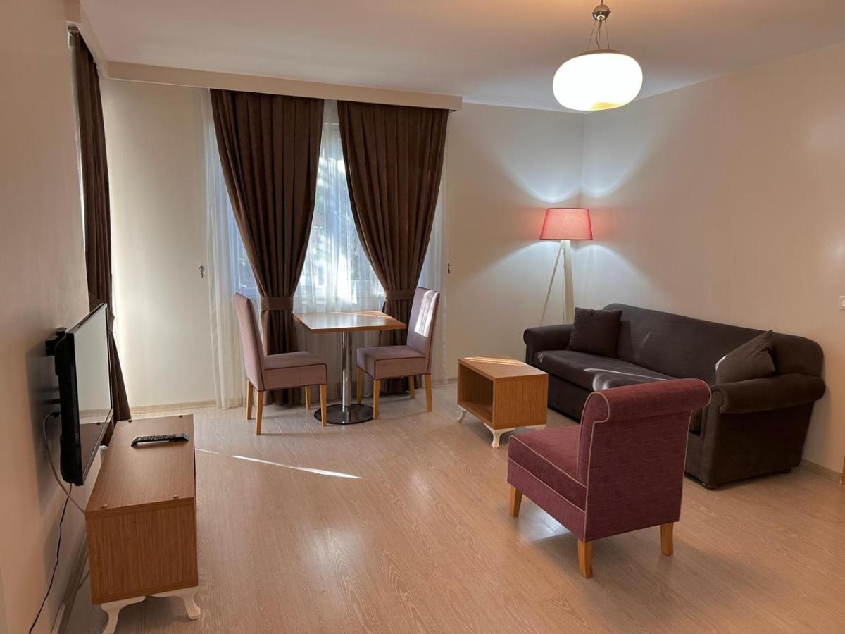 een woonkamer met een bank en een tafel bij Şeker Apartments in Tuzla