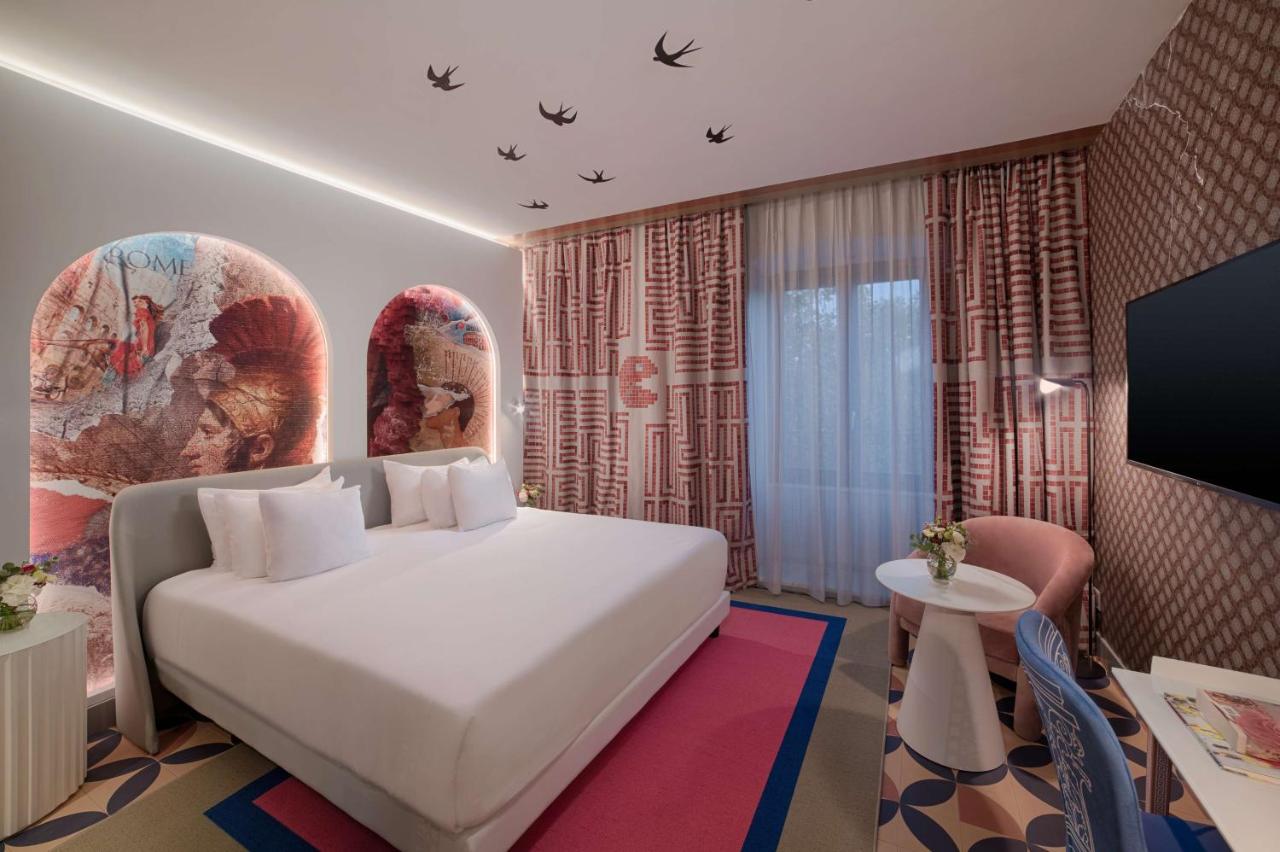 een hotelkamer met een wit bed en een tv bij nhow Roma Vittorio Veneto in Rome