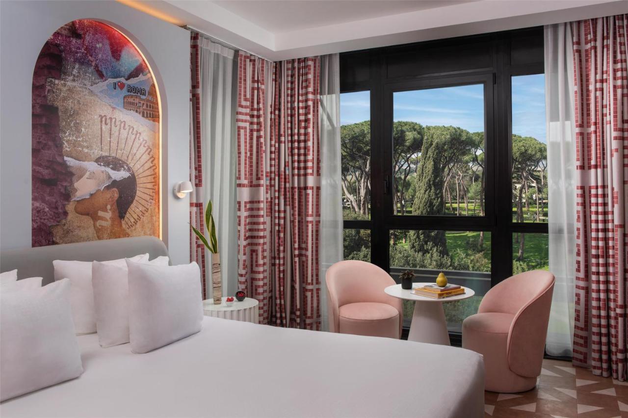 een slaapkamer met een wit bed en een groot raam bij nhow Roma Vittorio Veneto in Rome
