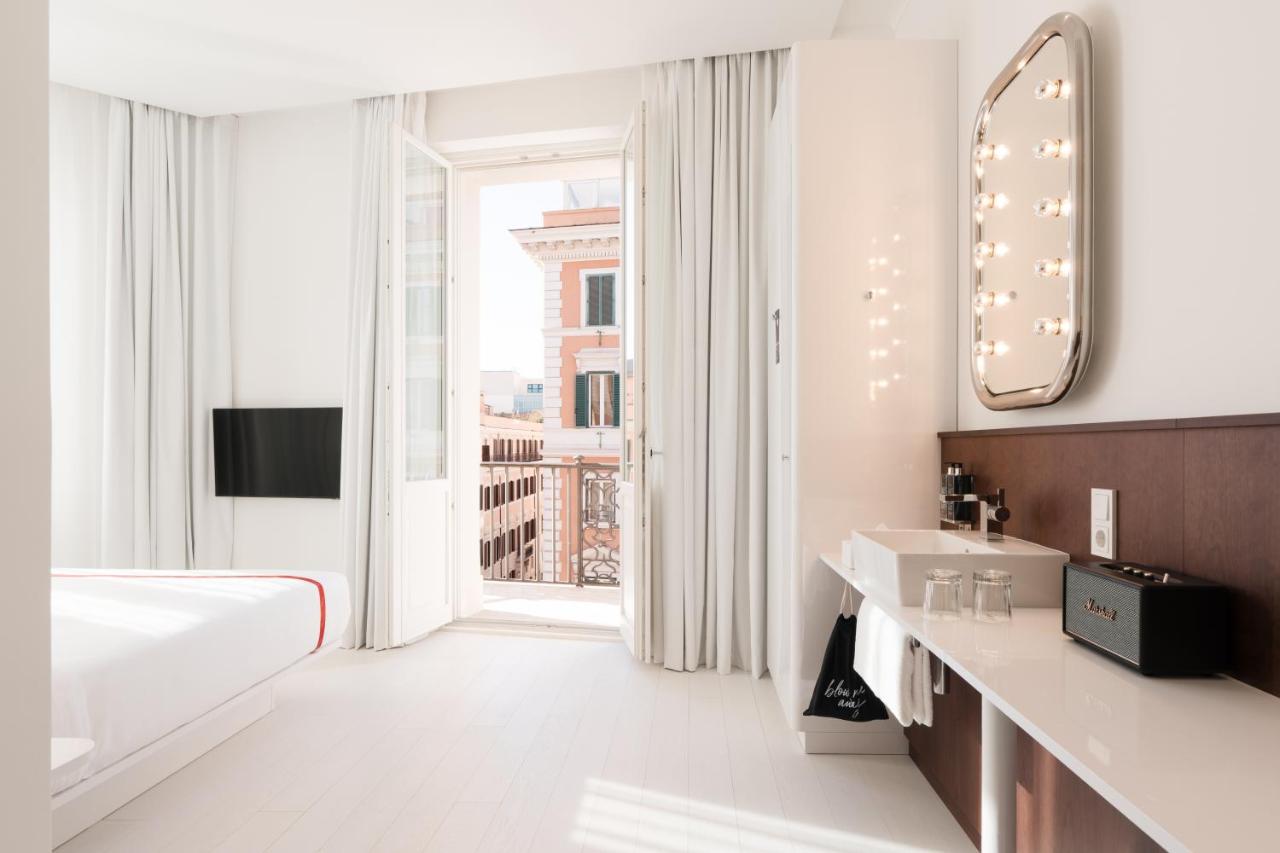 een witte badkamer met een spiegel en een groot raam bij Ruby Giulia Hotel Rome in Rome