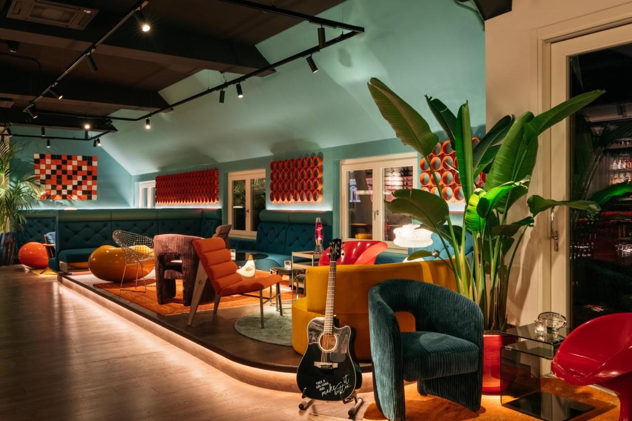 een woonkamer met stoelen en een gitaar in een kamer bij Ruby Giulia Hotel Rome in Rome