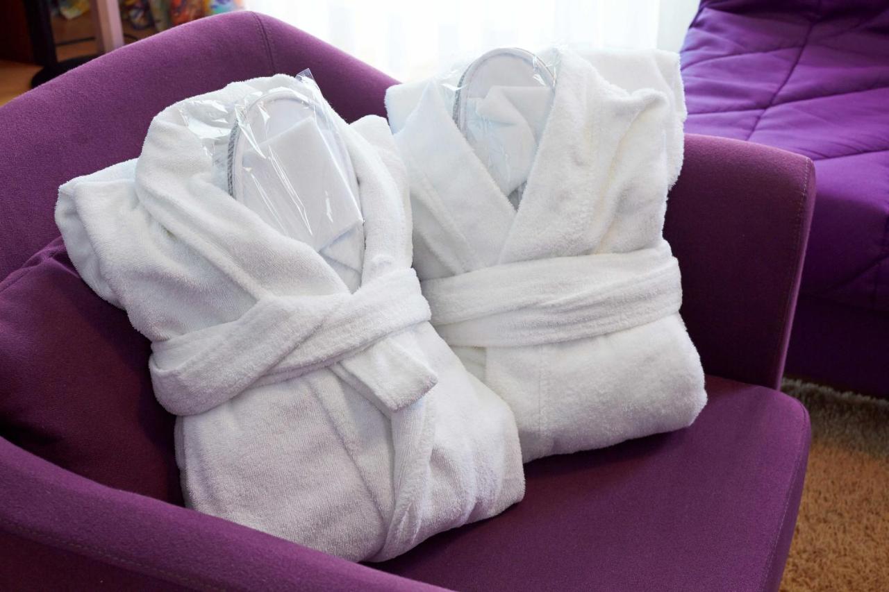 een paarse stoel met witte handdoeken erop bij Hotel Juliane in Merano