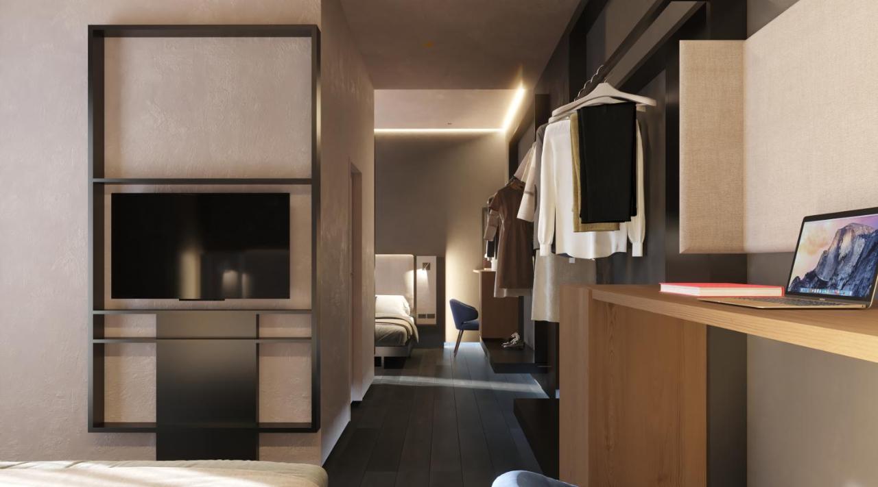 een hotelkamer met een bed en een bureau met een laptop bij Kira Suites Hotel Milano in Milaan