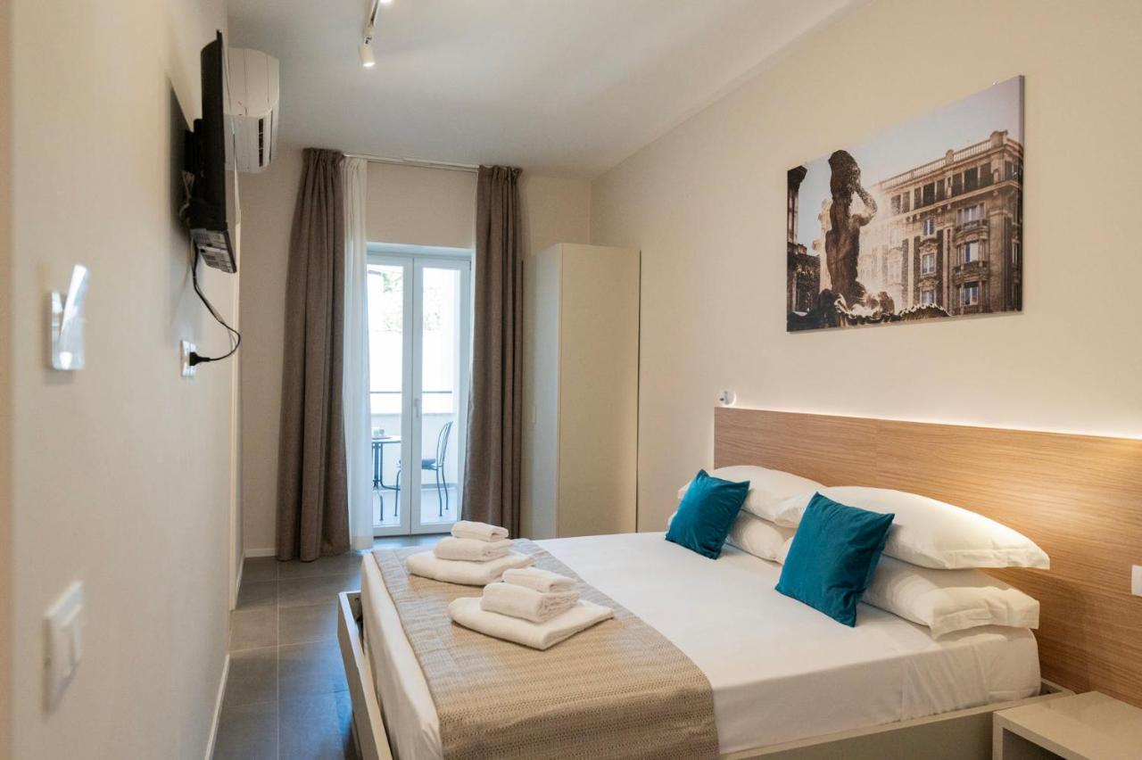 een slaapkamer met een groot bed met blauwe kussens bij imperium suite trevi in Rome