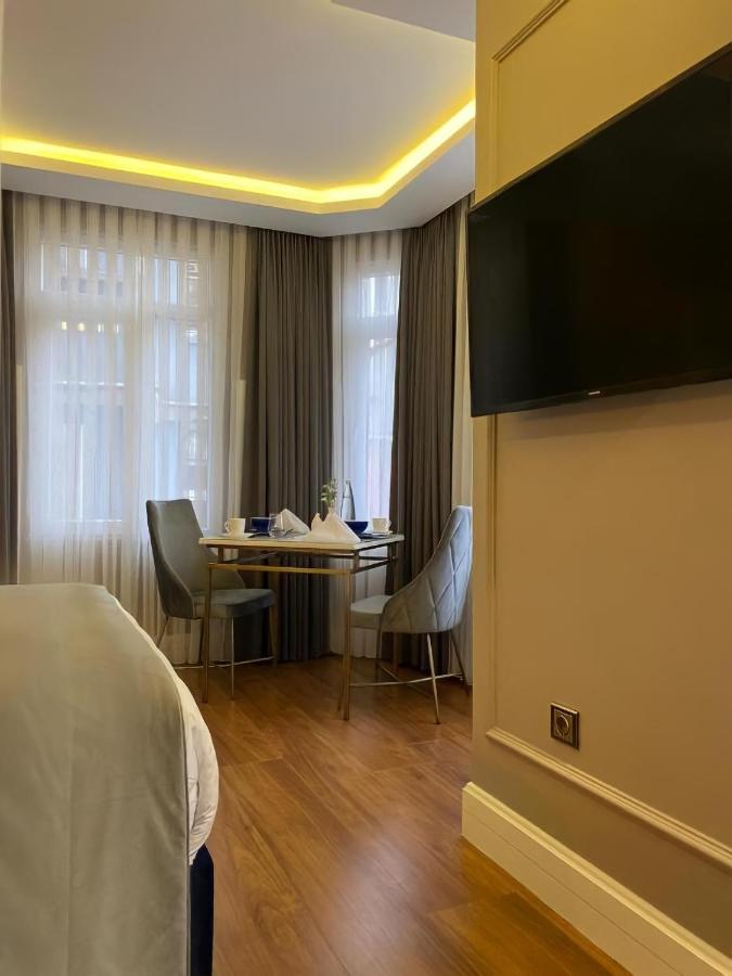 een hotelkamer met een bed en een tafel met stoelen bij Ozkaya Apartments Galata in Istanbul