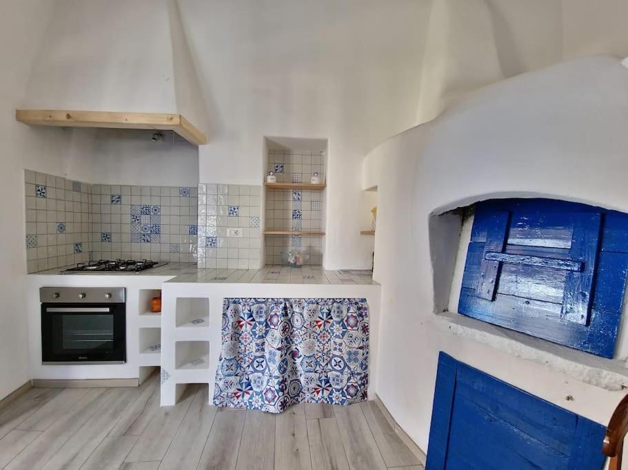 een keuken met witte aanrechtbladen en blauw-witte kasten bij Stromboli Vacanze in Stromboli
