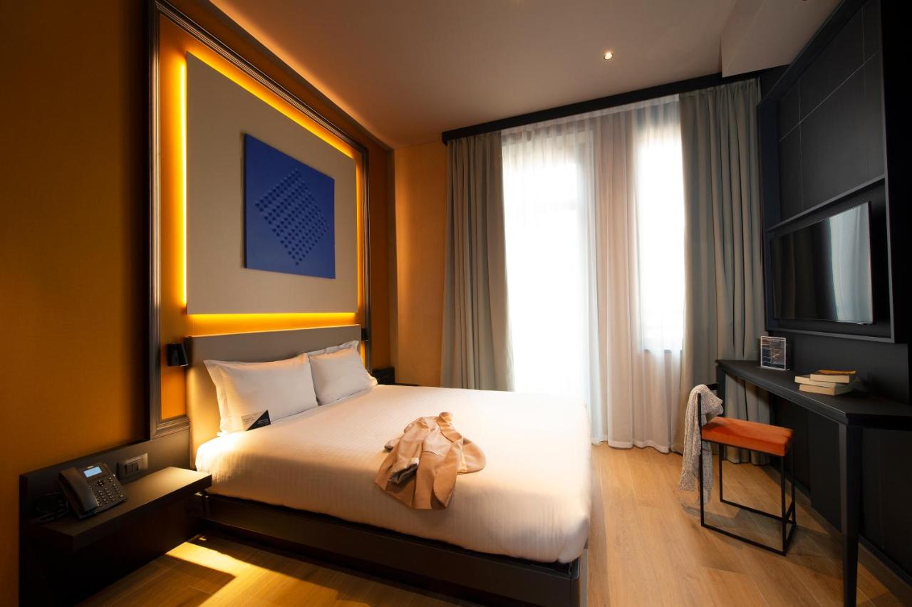 een hotelkamer met een bed en een televisie bij Palazzo Loreto Hotel Milano in Milaan