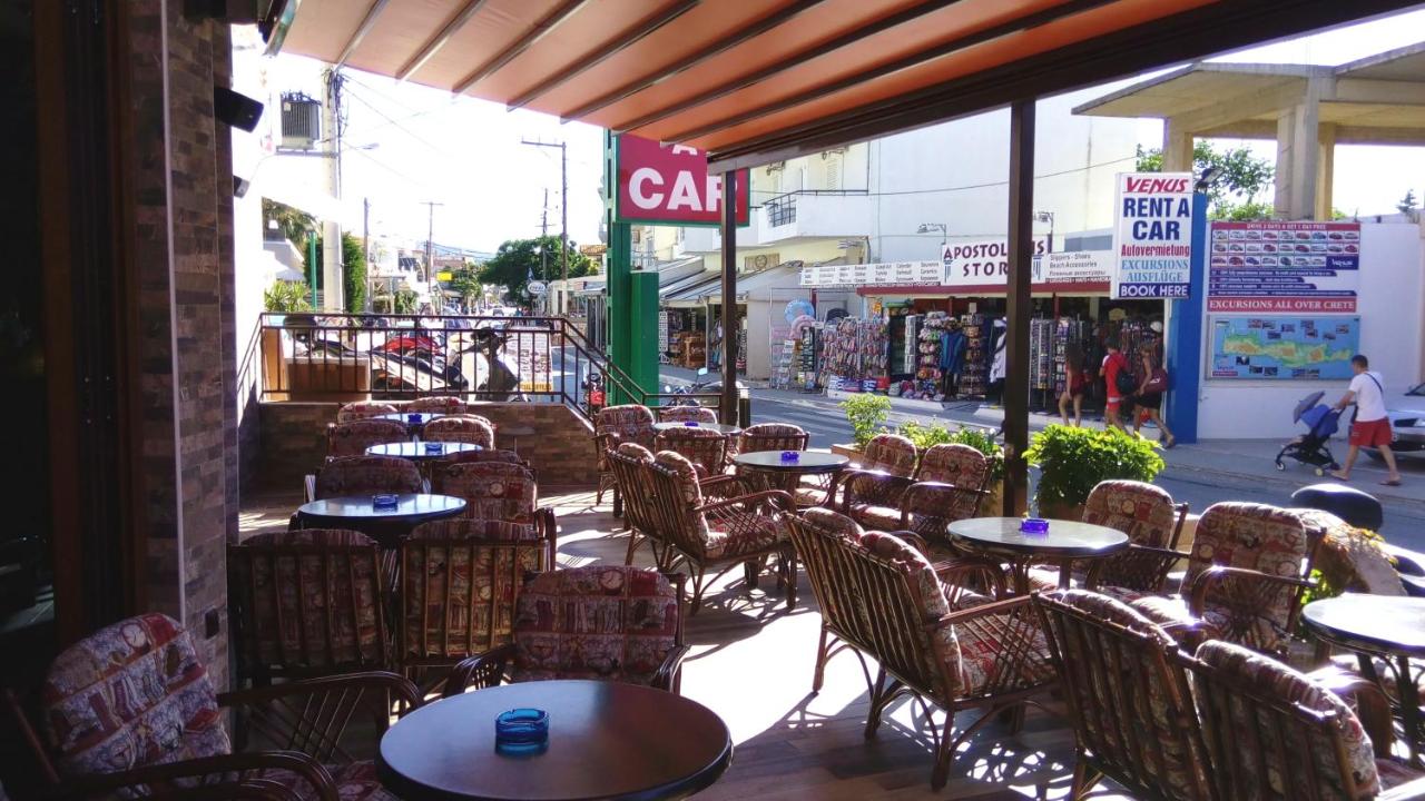 een leeg café met tafels en stoelen en een straat bij Katerini Apartments Hotel in Platanes
