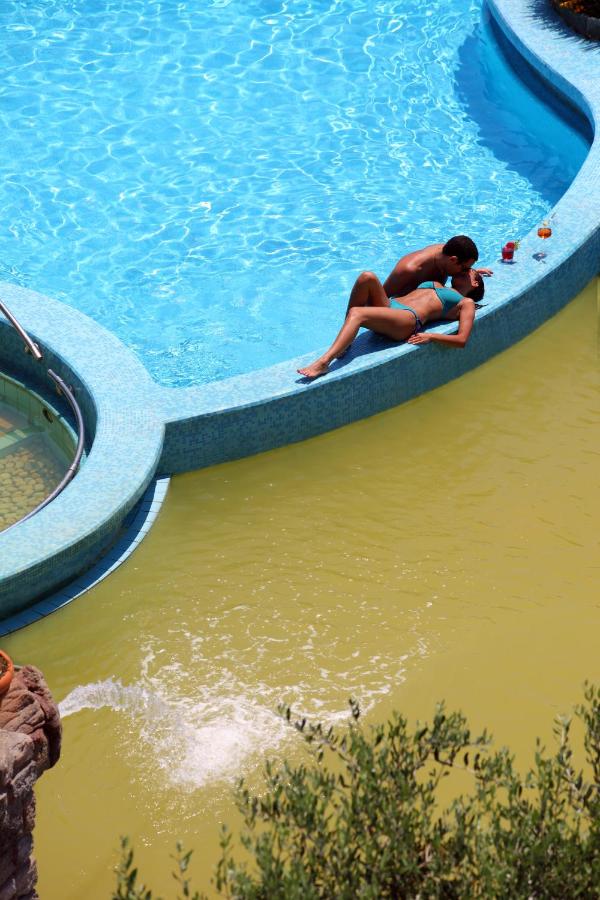 een vrouw die in een zwembad in het water ligt bij Hotel Terme Providence in Forio d'Ischia