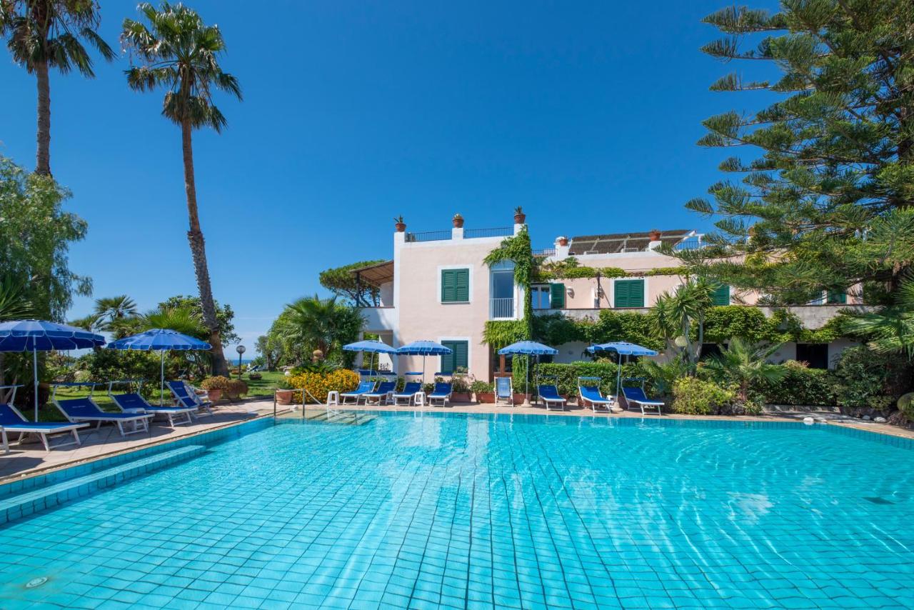 een zwembad met stoelen en parasols voor een gebouw bij Hotel Villa Melodie - Adults Only in Forio d'Ischia