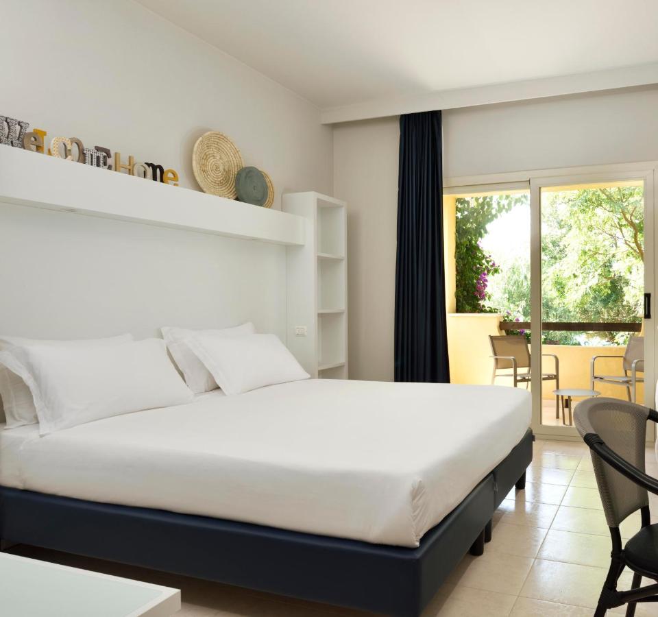 een slaapkamer met een bed, een tafel en stoelen bij Falkensteiner Club Funimation Garden Calabria in Curinga