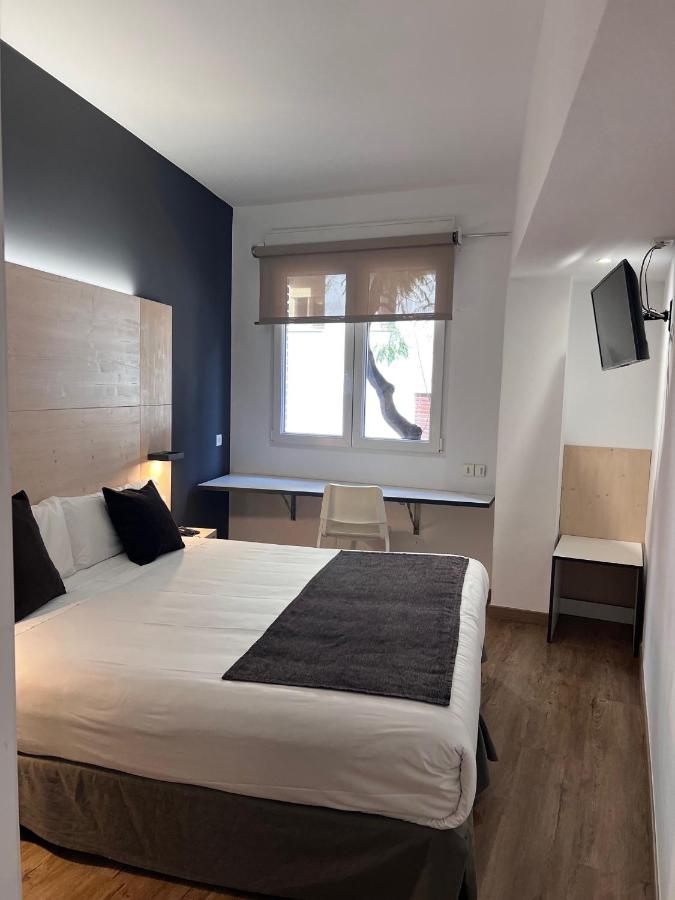 een slaapkamer met een groot bed en een raam bij Hotel Travessera in Barcelona