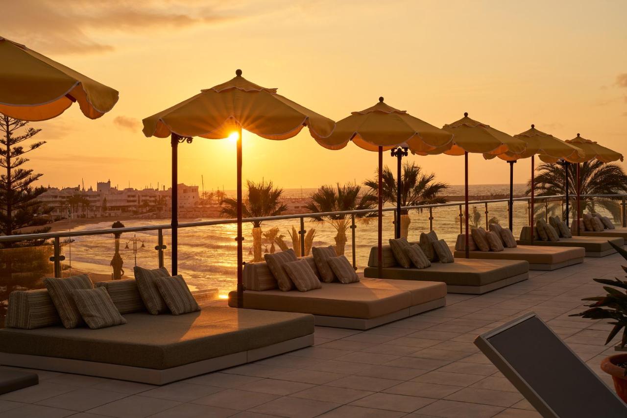 een rij tafels met kussens en parasols op een resort bij Hotel Riviera Costa del Sol - Adults Recommended in Benalmádena