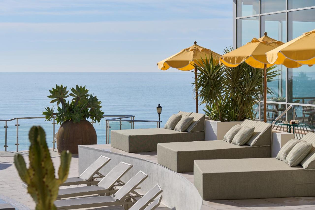 een terras met banken en stoelen en uitzicht op de oceaan bij Hotel Riviera Costa del Sol - Adults Recommended in Benalm