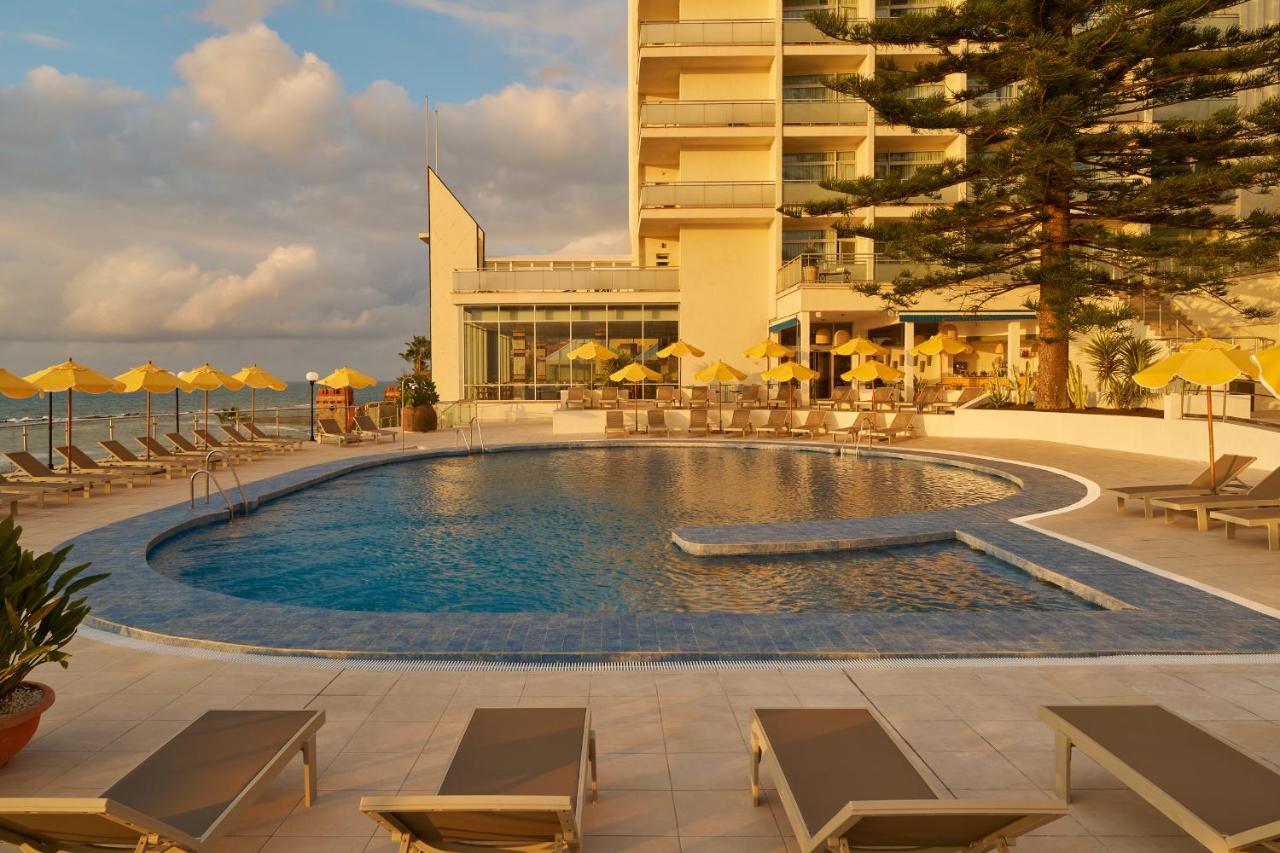 een zwembad met ligstoelen en een gebouw bij Hotel Riviera Costa del Sol - Adults Recommended in Benalmádena