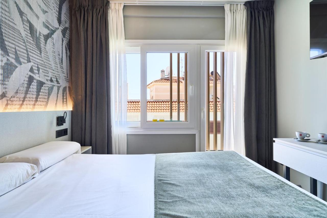 een hotelkamer met een bed en een raam bij Hostal Sol y Miel in Benalmádena