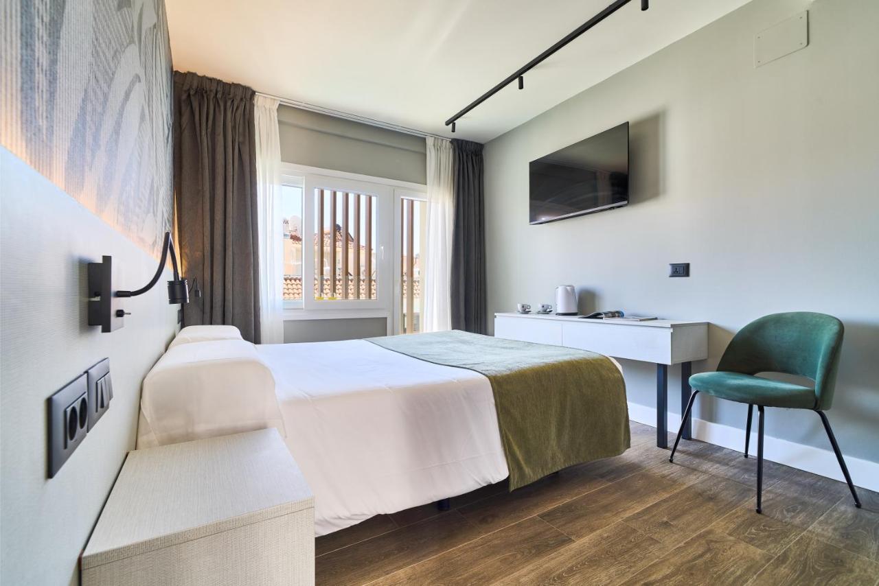 een hotelkamer met een bed en een stoel bij Hostal Sol y Miel in Benalmádena