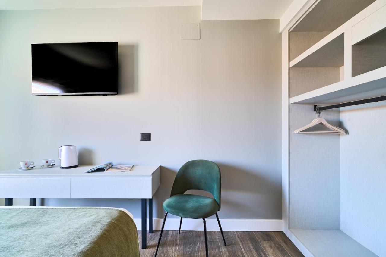 een slaapkamer met een bureau en een groene stoel bij Hostal Sol y Miel in Benalmádena