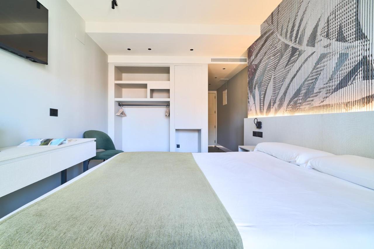 een slaapkamer met een groot bed en een tv bij Hostal Sol y Miel in Benalmádena