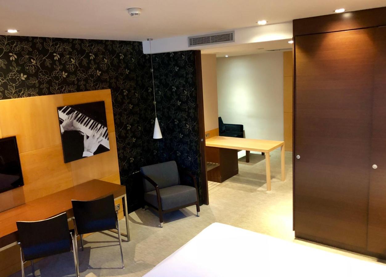 een kamer met een tafel en een bureau met een laptop bij Hotel Urpí in Sabadell