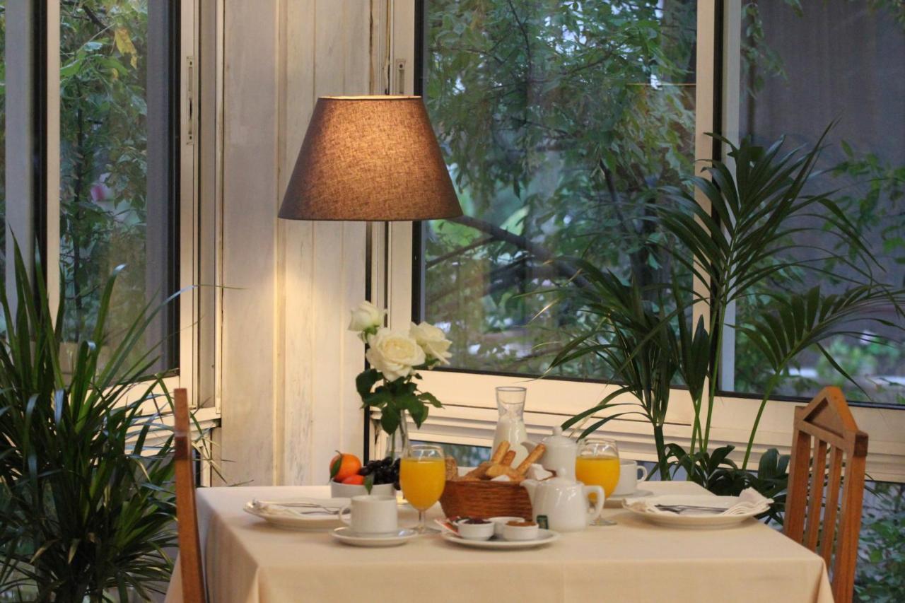 een tafel met een wit tafelkleed en een lamp bij Achillion Hotel in Athene