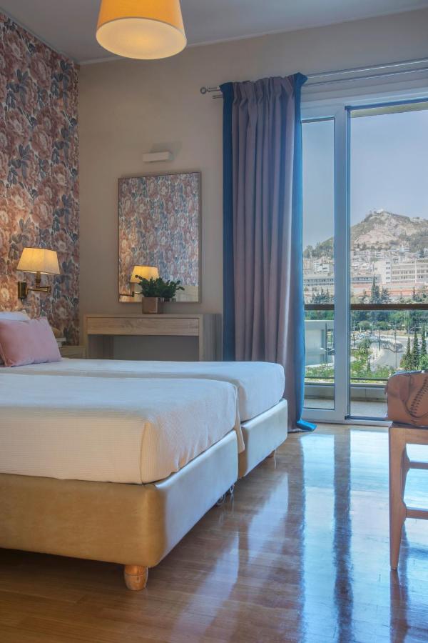 een slaapkamer met een groot bed en een groot raam bij Delice Hotel - Family Apartments in Athene