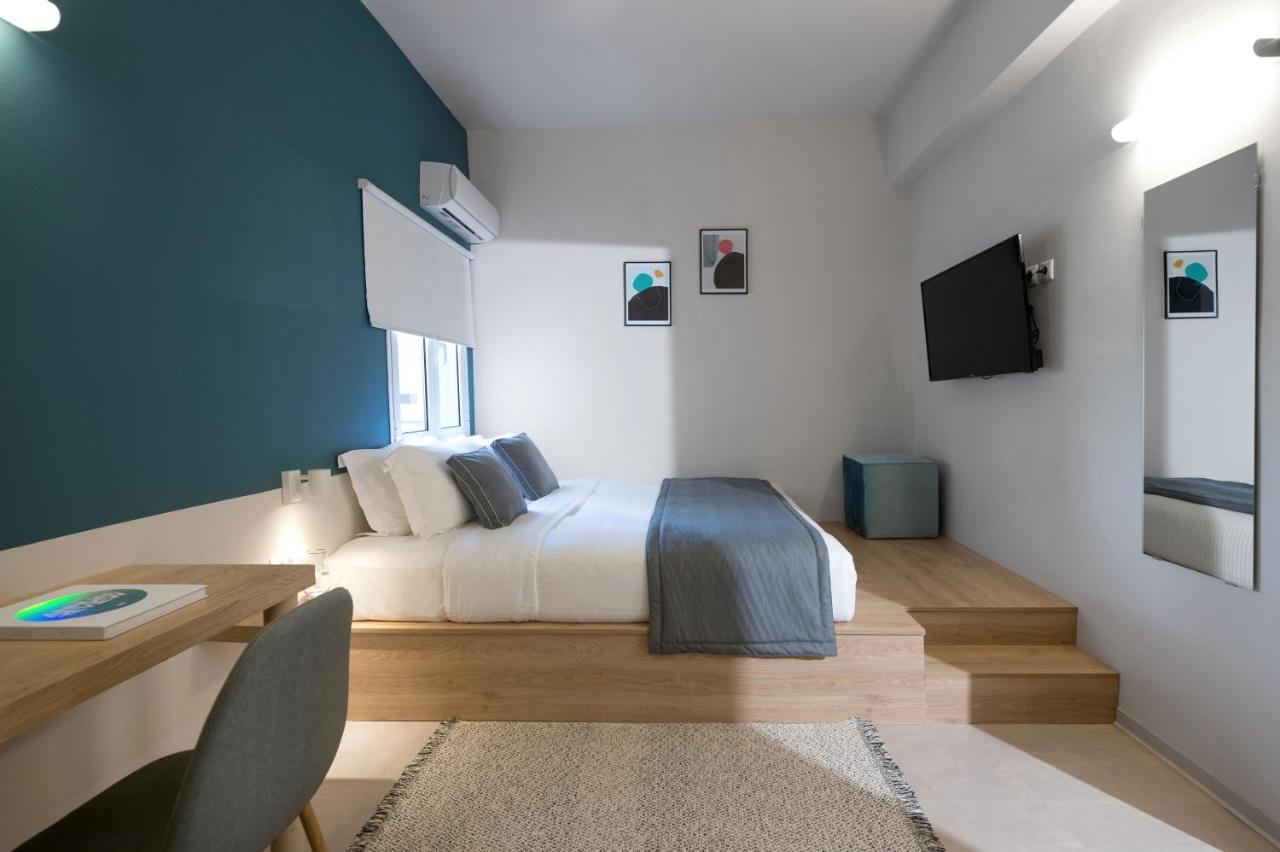 een slaapkamer met een bed, een bureau en een tv bij The Convo Athens Riviera in Athene