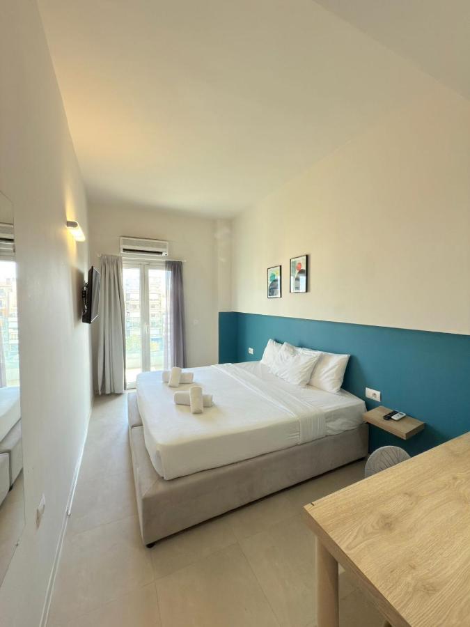 een slaapkamer met een groot bed en een blauwe muur bij The Convo Athens Riviera in Athene