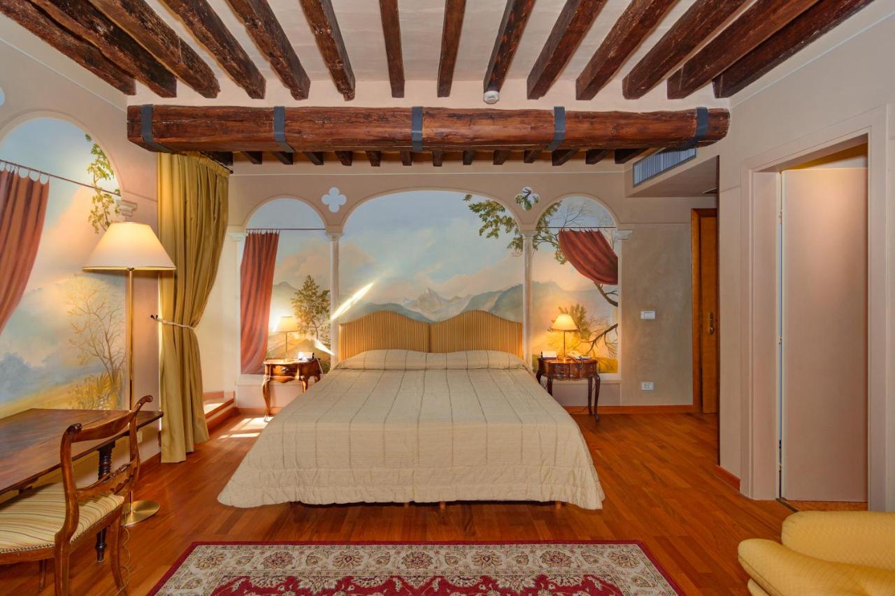 een slaapkamer met een bed en een schilderij aan de muur bij Hotel Villa La Principessa in Lucca