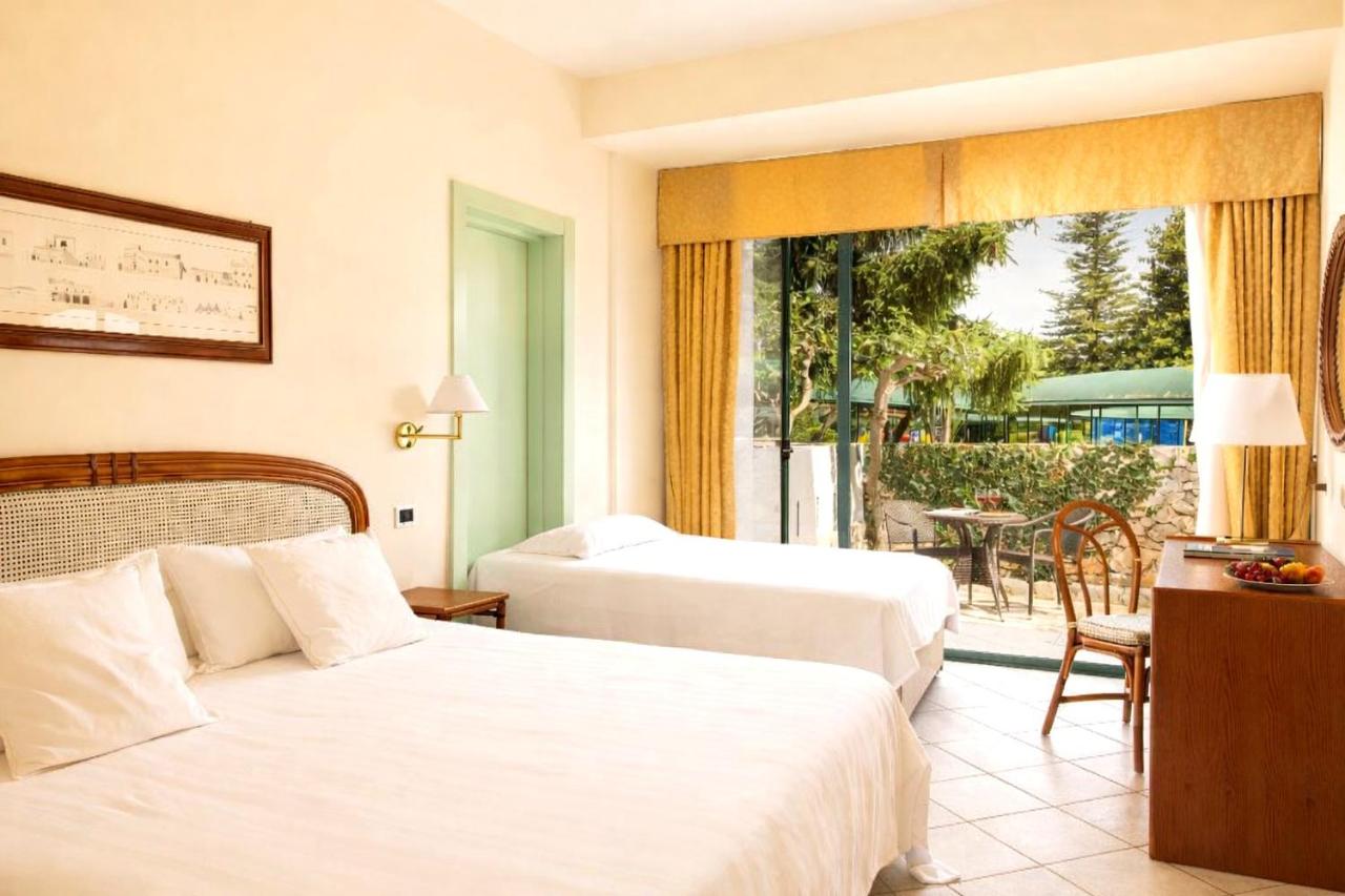 een hotelkamer met twee bedden en een balkon bij Hotel Sierra Silvana in Selva di Fasano