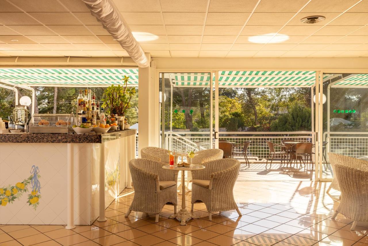 een terras met stoelen en een tafel op een veranda bij Hotel Sierra Silvana in Selva di Fasano